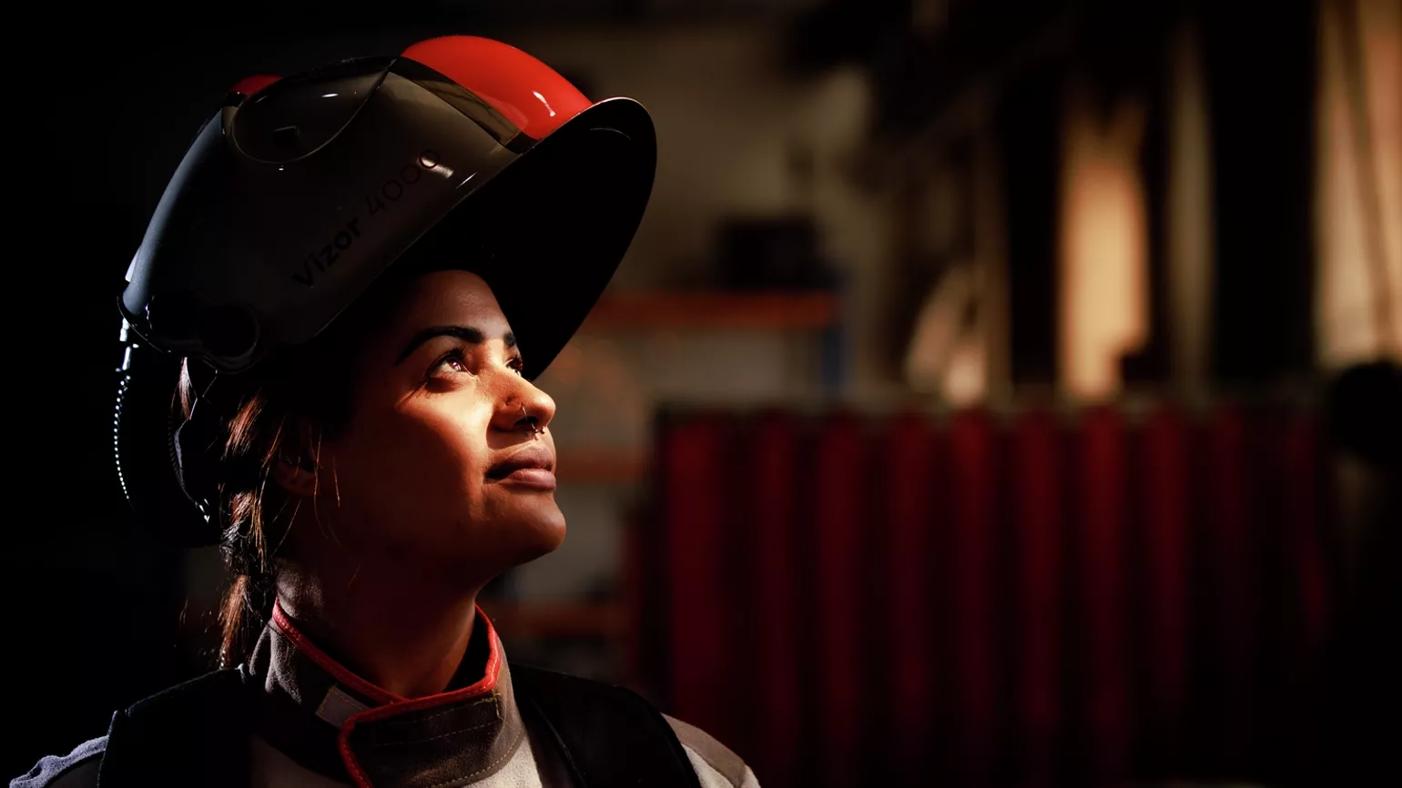 A welder with a Fronius Vizor 4000 helmet raised